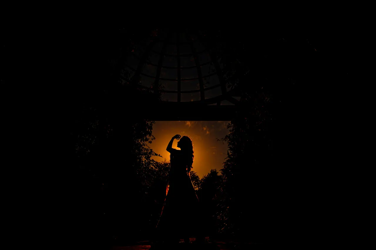 Silhouette einer Frau unter einem Pavillon vor goldenem Abendlicht